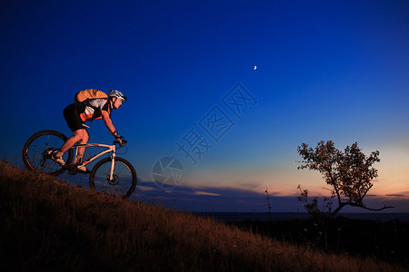 日落时天空背景上自行车的剪影图片