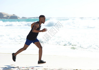 夏天在沙滩上跑步的年轻运动员图片
