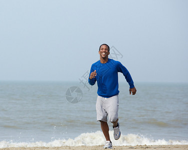 快乐的年轻人在沙滩上运动健康的图片