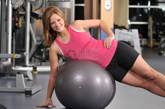 年轻女子微笑着在健身房锻炼图片