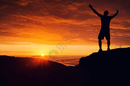 山顶上看云层日出的男人剪影图片素材