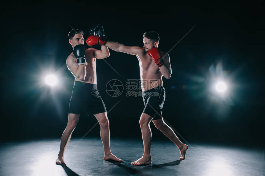 戴着拳击手套的赤膊肌肉发达的mma战士用拳头打另一个人高清图片下载-正版图片503548297-摄图网