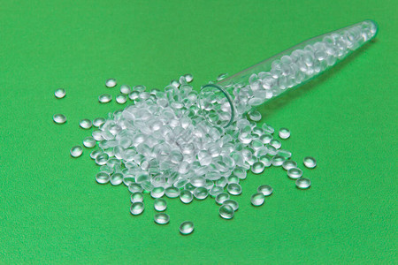 绿色背景上的透明聚乙烯颗粒游离双酚A的概念HDPE塑料颗粒塑料原图片