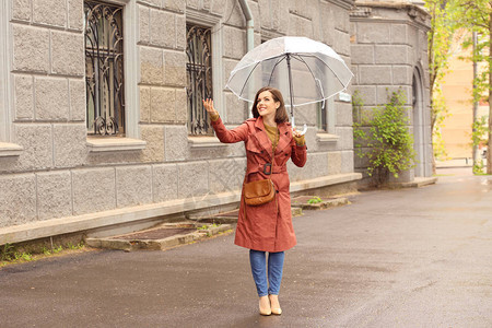 下雨天在户外打伞的漂亮年轻女子图片