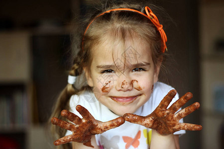 漂亮的微笑女孩用巧克力食物和饮料概念巧克力脸室内情感肖像图片