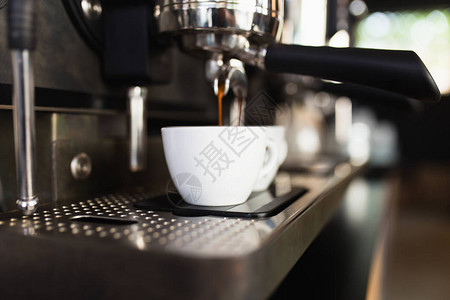意式咖啡意式浓缩咖啡从咖啡机倒入咖啡杯背景