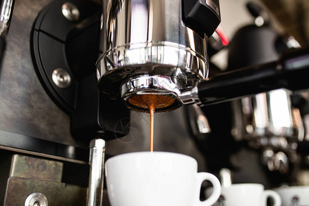 意式浓缩咖啡从咖啡机倒入咖啡杯图片