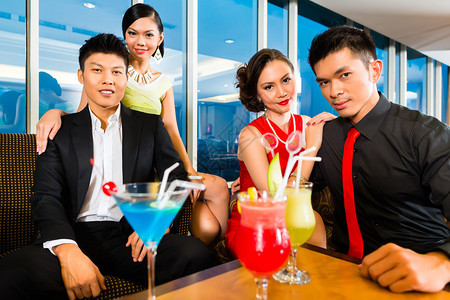 年轻英俊的亚洲华人在豪华别致的酒廊喝鸡尾酒喝鸡尾酒图片