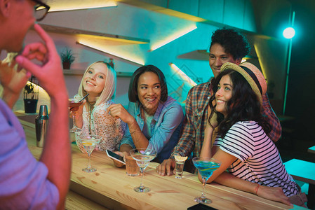 微笑着的多文化朋友与喝酒的朋友在图片