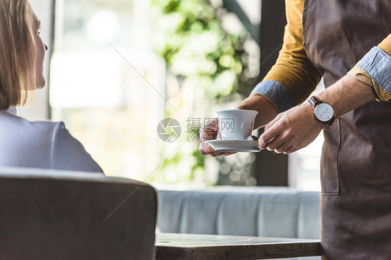 为咖啡馆女客户提供咖啡杯的服图片