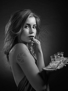迷人的金发女人带着龙舌兰酒和石灰杯美丽的专业图片