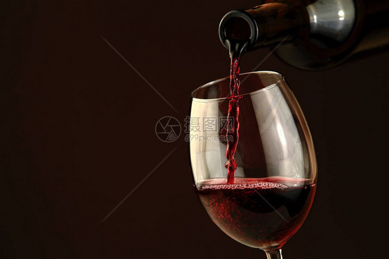 红酒倒入玻璃特写镜头从瓶子里流出的酒图片