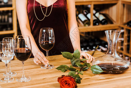 妇女穿着红裙子戴葡萄酒杯和在酒图片