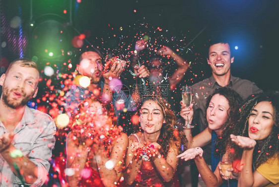 快乐的朋友在夜总会做派对扔纸屑一群年轻人在迪斯科俱乐部一起庆祝假期青年文化娱乐图片
