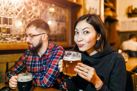 一个女人和她的朋友在布拉格的一家酒馆里尝试新酿的图片