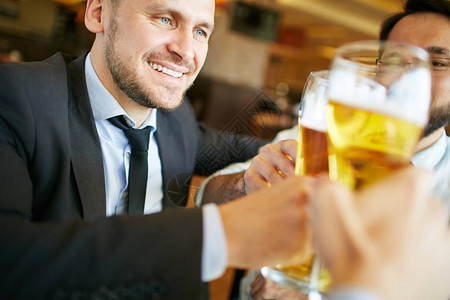 生意人和朋友在酒吧喝啤酒图片