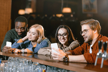 在酒吧看智能手机屏幕的有吸引力的图片