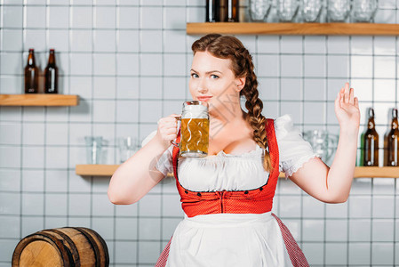 在酒吧柜台附近喝着轻啤酒的传统巴伐利亚服图片