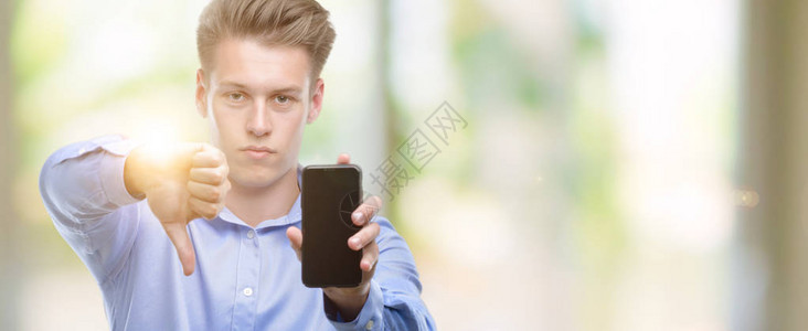 英俊的金发年轻男子使用智能手机满脸愤怒的脸图片