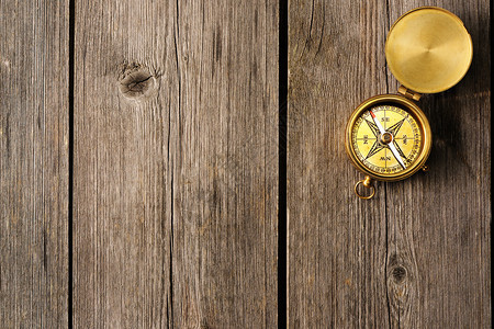 在木背景的古色香的黄铜指南针背景图片
