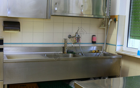 学校食堂工业厨房的钢水池和工作图片