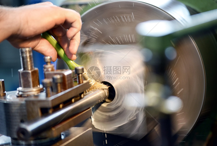 男人把润滑油放在一个工程或工业车间的衣板上图片