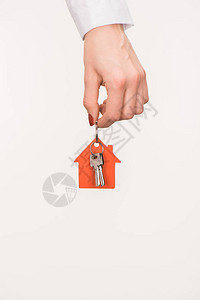 女手握着从孤立在白色房屋中走出的钥背景图片