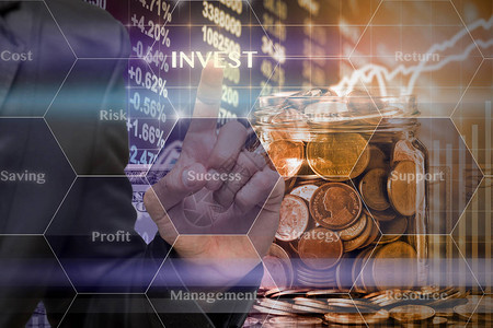 商人在透明瓶中的金币和LED显示屏上的美元货币上用商业成功虚拟屏幕触摸Invest图标股票市场交易数背景图片