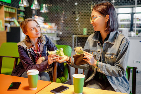 一个女人在咖啡馆里给陌生人或她的朋友欧元钞票钱借钱图片