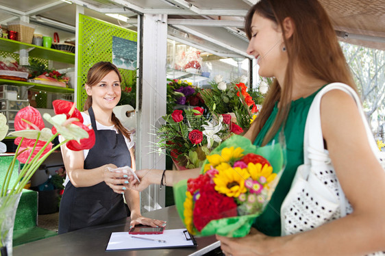 有魅力的女顾客在花店里用现金买一小束向日葵图片