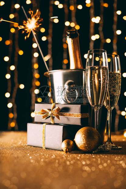 桶中的香槟礼物和圣诞灯饰在花环图片