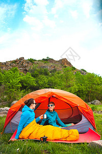 两个女孩坐在帐篷里女朋友在大自然中交流睡袋里的女人喝咖啡露营地的朋友微图片