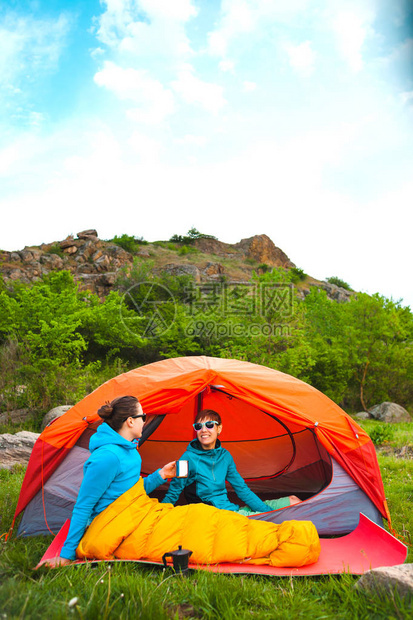 两个女孩坐在帐篷里女朋友在大自然中交流睡袋里的女人喝咖啡露营地的朋友微图片