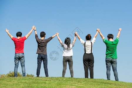 一群快乐的年轻人在泰国曼谷公园一起举手来图片素材