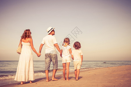 幸福的家庭白天在沙滩上走来去友背景图片