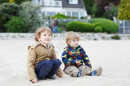 两个小孩坐在Elbe河的海滩上图片
