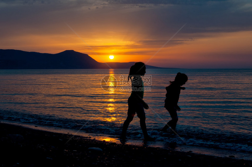 两名儿童在海滩上与海边日图片