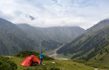 从帐篷里面看山景露营概念帐篷内的日落年轻女子坐在帐篷里图片