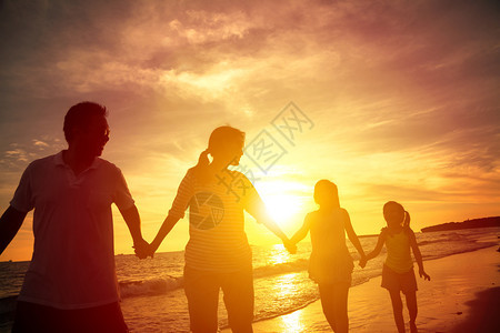 幸福一家人走在沙滩上的剪影图片