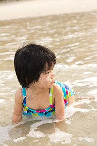 小女孩在沙滩上享受海浪图片