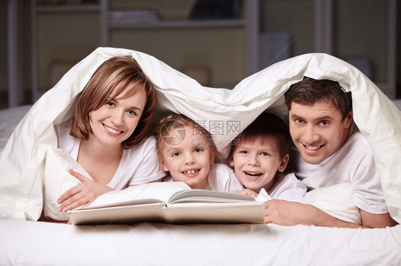 父母与子女在毛毯下的图片