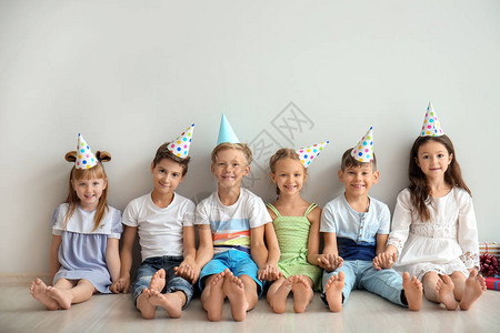 穿着生日帽子的可爱小孩坐在靠近图片