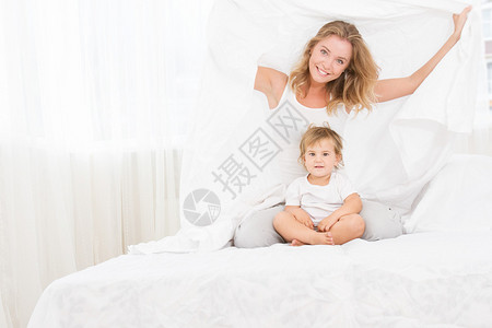 清晨在家床上睡觉的年轻幸福母亲和婴幼图片