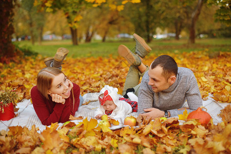 恋爱中的情侣躺在公园的秋天落叶上图片