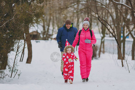 欢笑的家庭妇女穿着温暖衣服跑步的男小姑娘在雪地公园或露户森林中行走冬季娱乐节假日休闲爱童关系家庭生活方图片