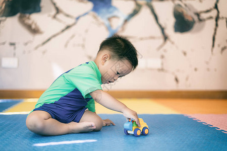 亚洲小男孩在家里玩具车图片