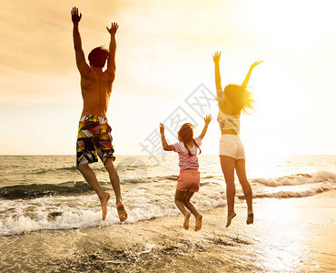 快乐的家庭在沙滩上跳跃图片