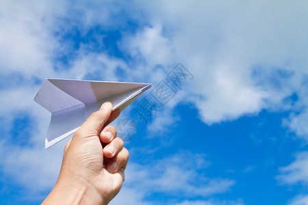 有纸飞机的手反对蓝天图片
