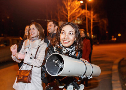 夜里一群人用大型专业望远镜和微笑仰望星图片