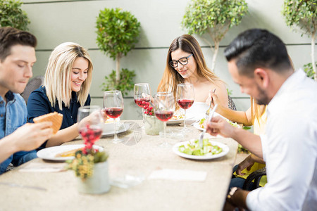 社会经济五群年轻人在餐厅露台吃午餐背景